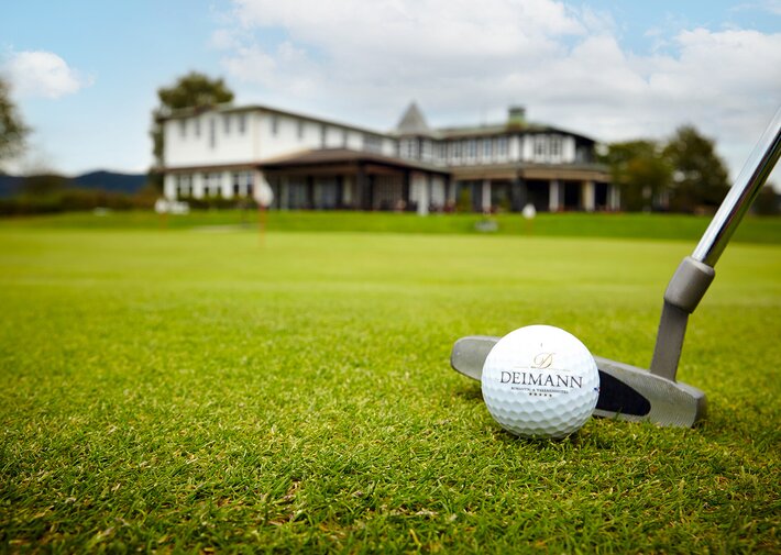 Golfball auf dem Golfplatz mit Deimann Schriftzug