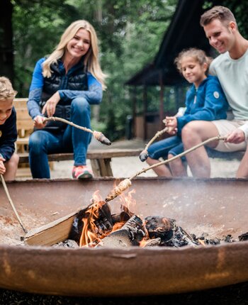 Familie macht Stockbrot am Lagerfeuer
