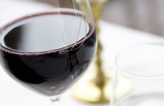 Ein Glas Rotwein mit der Aufschrift "D" für das Romantik- und Wellnesshotel Deimann 