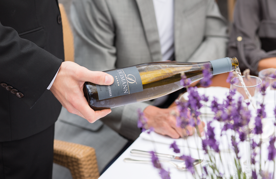 Ein Kellner serviert den Hauswein des Romantik- und Wellnesshotels Deimann 