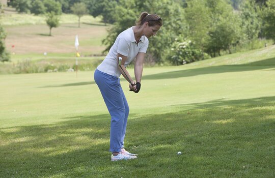 Eine Frau schlägt einen Ball im Golfhotel in NRW