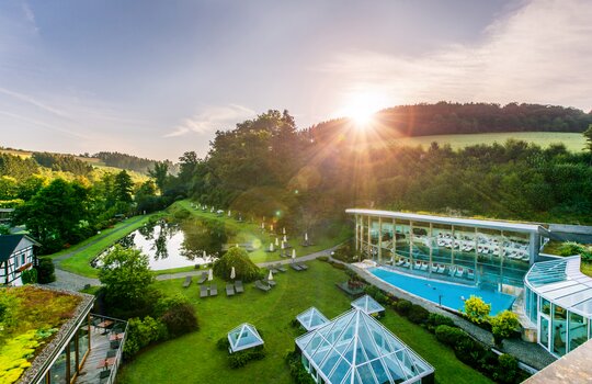 Der Garten des Wellnessbereichs im Romantik- und Wellnesshotel Deimann in Vogelperspektive bei Sonnenuntergang 