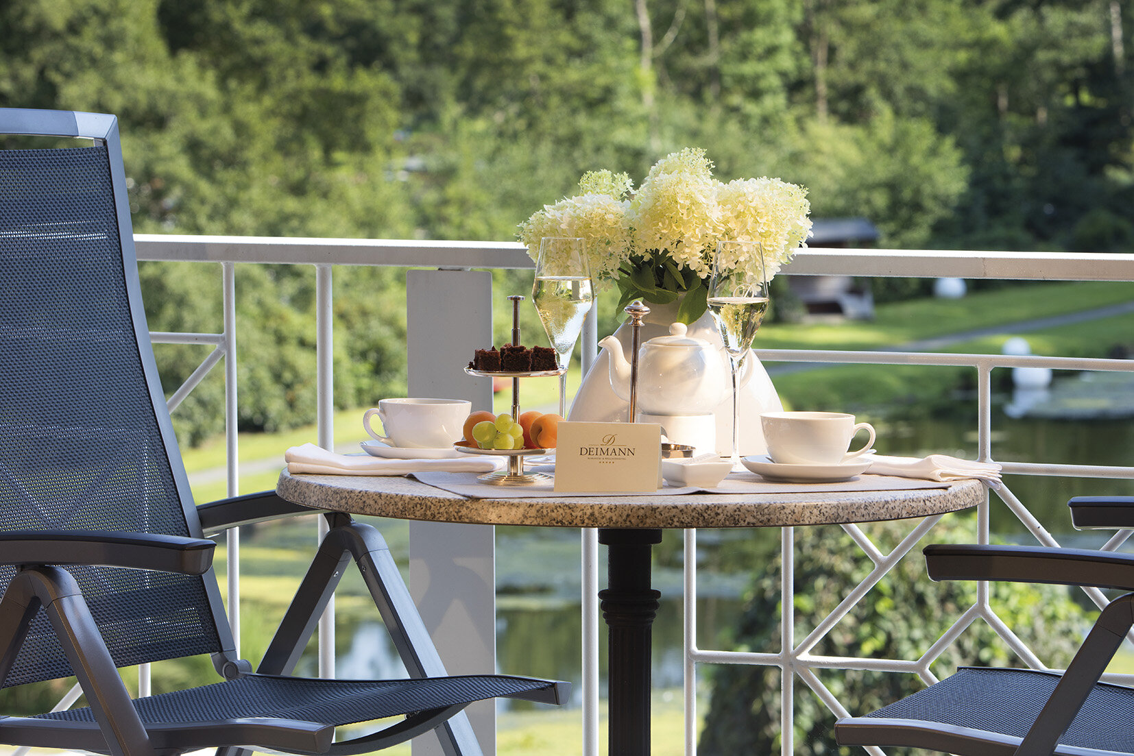 Ein schön gedeckter Bistrotisch mit Sektgläsern und Snacks vor dem Hotel 