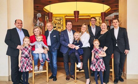 Die gesamte festlich gekleidete Familie Deimann lächelt für ein Familienfoto