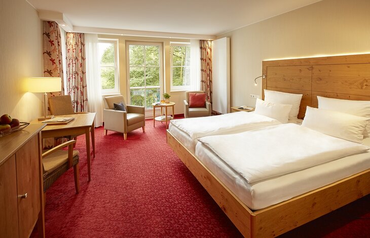 Ein Einblick in das Doppelzimmer Holzkontor mit einem großem Doppelbett aus dem Romantik- und Wellnesshotel Deimann