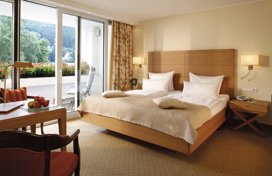 Das Doppelzimmerr "Superior" in der alten Sägerei im Hotel Deimann, ausgetattet mit einem großen Doppelbett und einem Balkon.