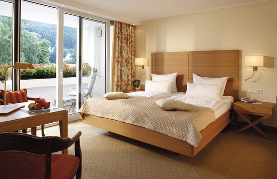 Das Doppelzimmer "Superior" in der alten Sägerei im Romantik- und Wellnesshotel Deimann, ausgestattet mit einem großen Doppelbett und einem Balkon
