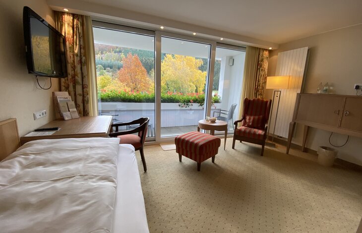 Der gemütliche Sitzbereich vor einer großen Fensterfront in der Junior Suite Superior "Alte Sägerei"
