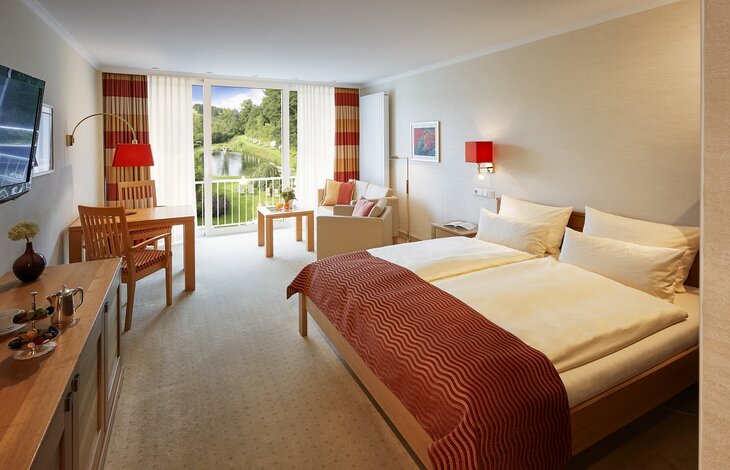 Einblick in den Schlafbereich mit Zugang zum Balkon der Junior Suite Superior Gutshof 