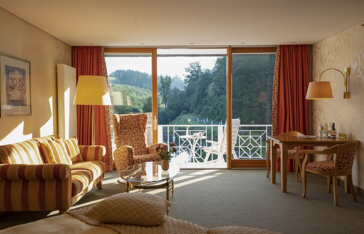 Einblick in den Wohnbereich mit angrenzendem Balkon in der Junior Suite Superior "Haupthaus"