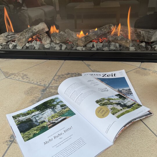 Zwei Magazine der "Deimann Zeit" vor einem brennenden Kamin