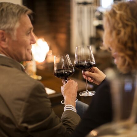 Eine Mann und eine Frau mit zwei Rotweingläsern im Restaurant "Störmann"