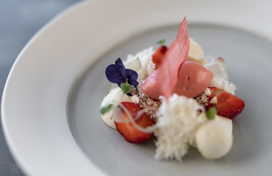 Ein liebevoll zubereitetes Gourmetdessert auf einem weißen Teller 