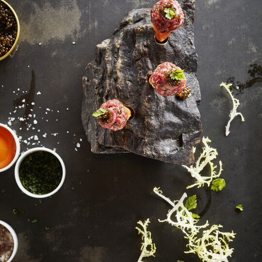 Drei Tartar mit Kaviar auf einer schroffen Steinplatte 