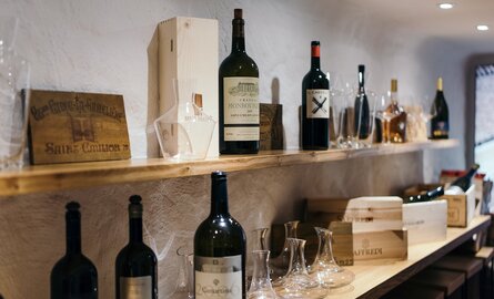 Eine Detailaufnahme  einiger Weinflaschen auf Regalen im Weinkeller des Romantik- und Wellnesshotels Deimann 