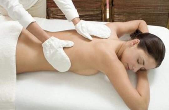 Eine Frau liegt auf dem Bauch bei einer Garshan-Peeling-Massage im Wellnesshotel Deimann in NRW 