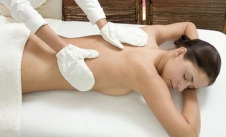 Eine Frau liegt auf dem Bauch bei einer Garshan-Peeling-Massage.