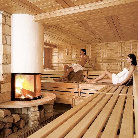 Eine Frau und ein Mann sitzen zusammen in der Sauna ihres Wellnesshotel ins NRW