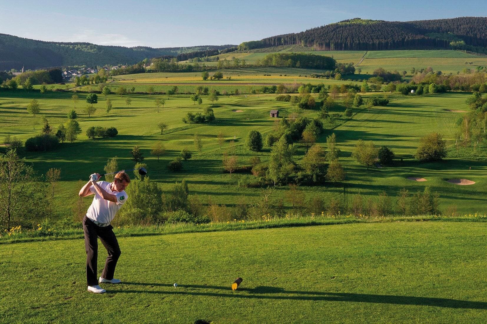 Golfhotel Deimann im SauerlandEin Golfer genießt seinen Urlaub im Golfhotel in NRW und spielt eine Runde auf dem großen und weiten, grünen Golfplatz 