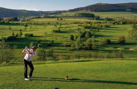 Golfhotel Deimann im SauerlandEin Golfer genießt seinen Urlaub im Golfhotel in NRW und spielt eine Runde auf dem großen und weiten, grünen Golfplatz 