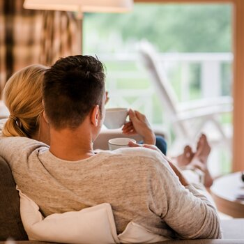 Pärchen trinkt Kaffee auf einer Couch im Hotel Deimann