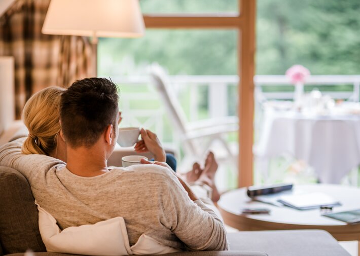 Pärchen trinkt Kaffee auf einer Couch im Hotel Deimann