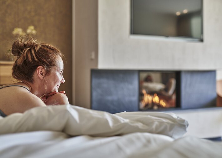 Frau genießt Bett im Hotel Deimann