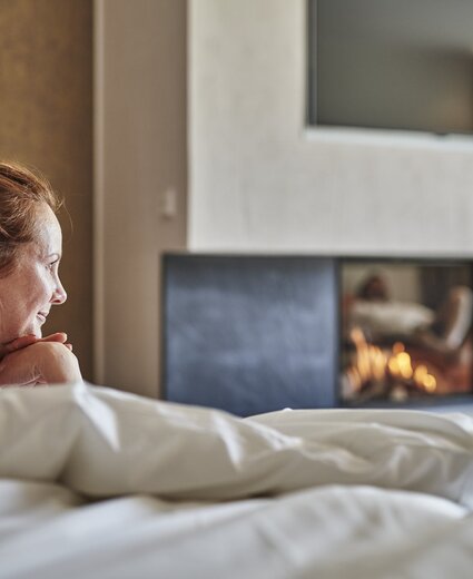 Frau genießt Bett im Hotel Deimann
