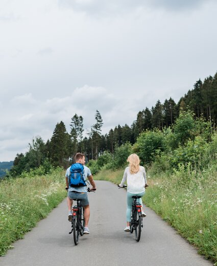 Zwei Gäste des Aktivhotels am Winterberg genießen eine Fahrradtour im Gebirge 