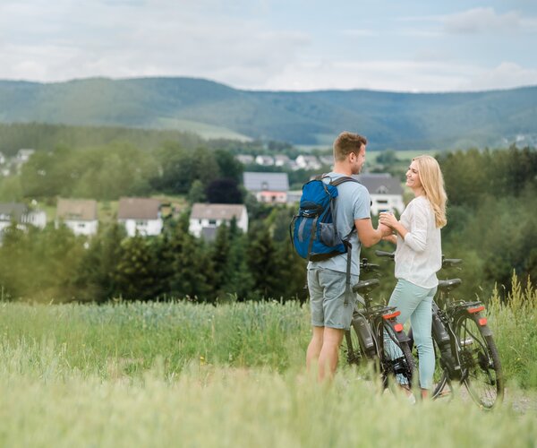 Ein Pärchen mit zwei Fahrrädern sieht sich verträumt in dem Gebirge des Sauerlands an