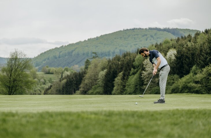 Mann beim Abschlag auf dem Golfplatz Hotel Deimann