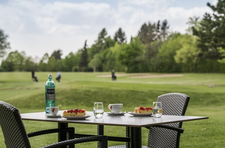 Kuchen und Wasser auf dem Tisch des Deimanns Golf Café
