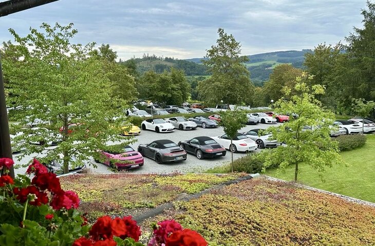 Parkplatz mit Porsche Autos vor dem Hotel Deimann