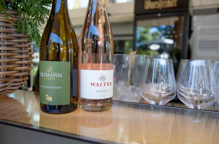 Zwei Flaschen Wein mit Gläsern aus dem Hotel Deimann