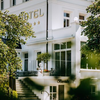 Blick durch Blätter auf das 5 Sterne Hotel Deimann
